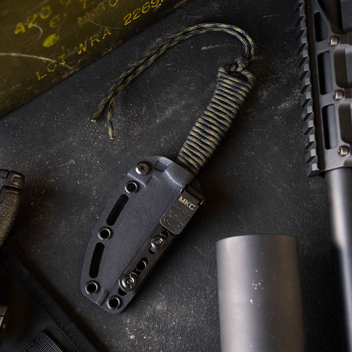 Tactical Speedgoat knife in black and dark camo, featuring a textured handle and sheath, ideal for outdoor use.