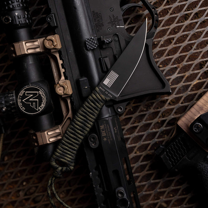 Tactical Speedgoat knife in black and dark camo, featuring a rugged design and paracord handle, alongside tactical gear.