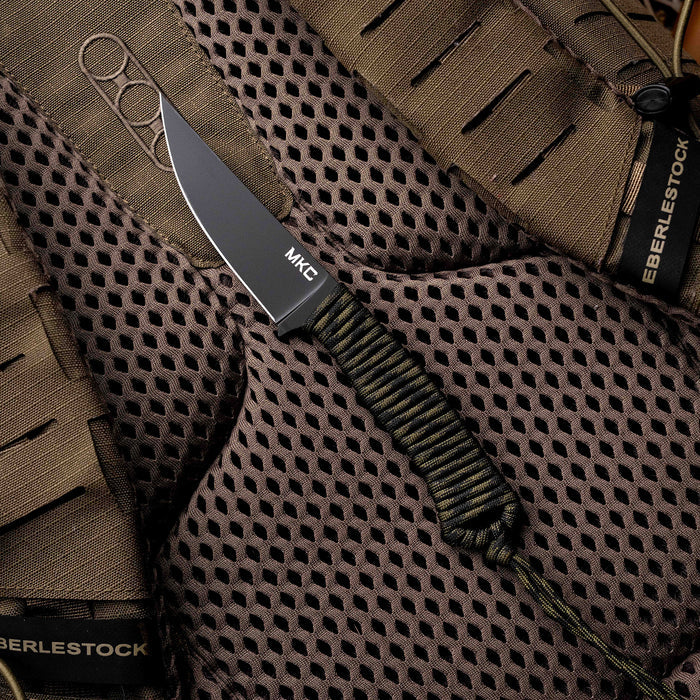 Tactical Speedgoat knife in black and dark camo, featuring a textured handle and sleek blade, displayed on tactical gear.