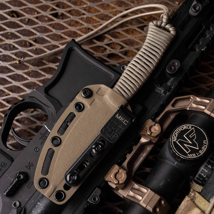 Tactical Speedgoat knife in coy/olv color mounted on a firearm with a paracord handle and sheath. Ideal for tactical use.