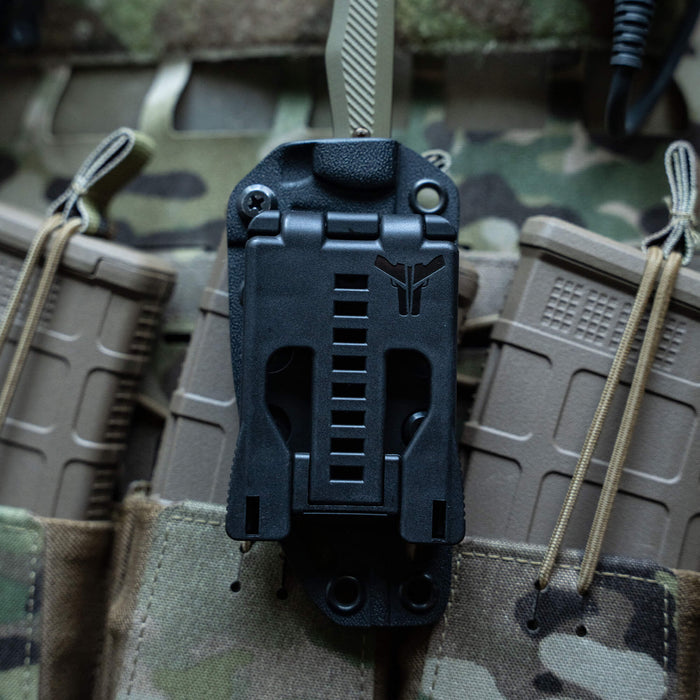 TEK-LOK belt attachment securely mounted on tactical gear, designed for versatile knife and tool carrying.