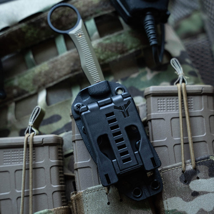 TEK-LOK belt attachment mounted on tactical gear, designed for secure and versatile knife carrying.