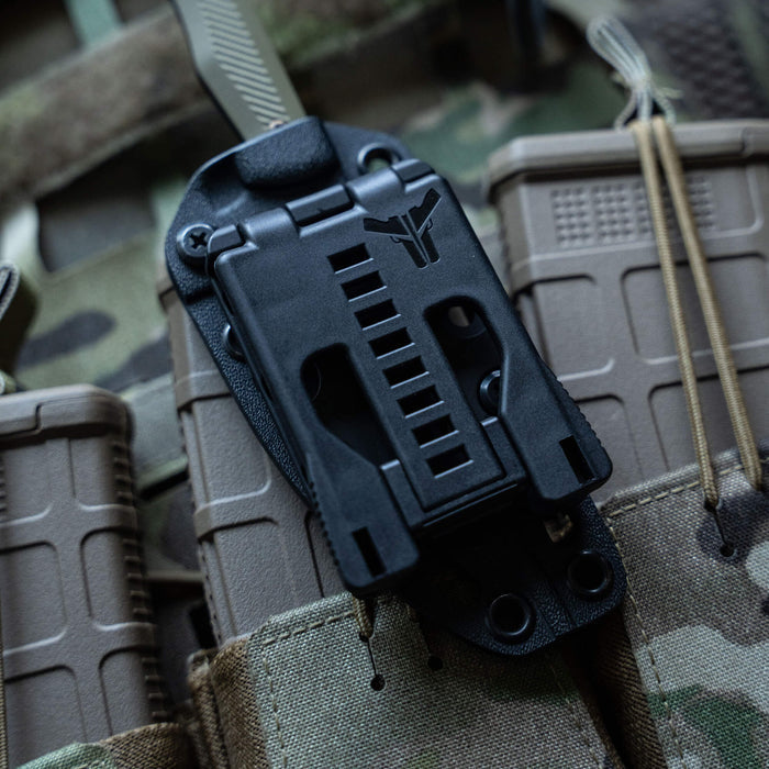 TEK-LOK belt attachment securely mounted on tactical gear, designed for versatile knife and tool carrying.