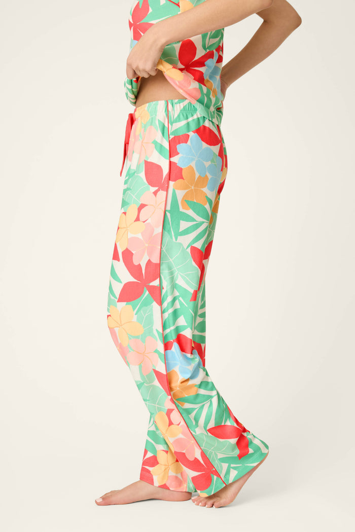 Buttery-soft jersey fabric featuring a vibrant tropical floral print in sunset hues.