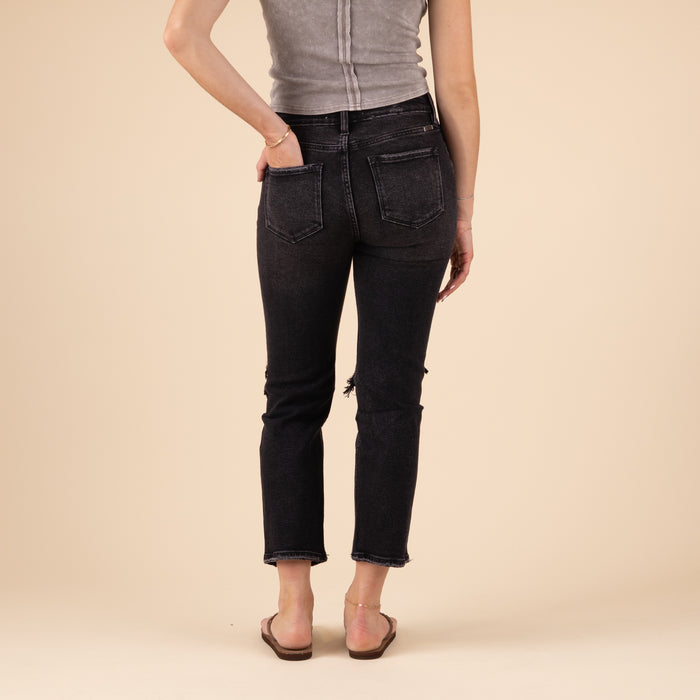 Back view of the jeans featuring standard back pockets, a fitted waistband, and straight-cut legs. The black denim has a solid tone with minimal distressing on the back.