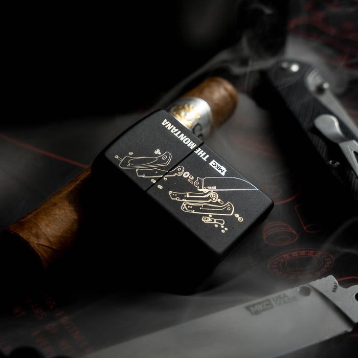 USA-made Montana Traditional windproof Zippo lighter with intricate design, placed beside a cigar and a knife.