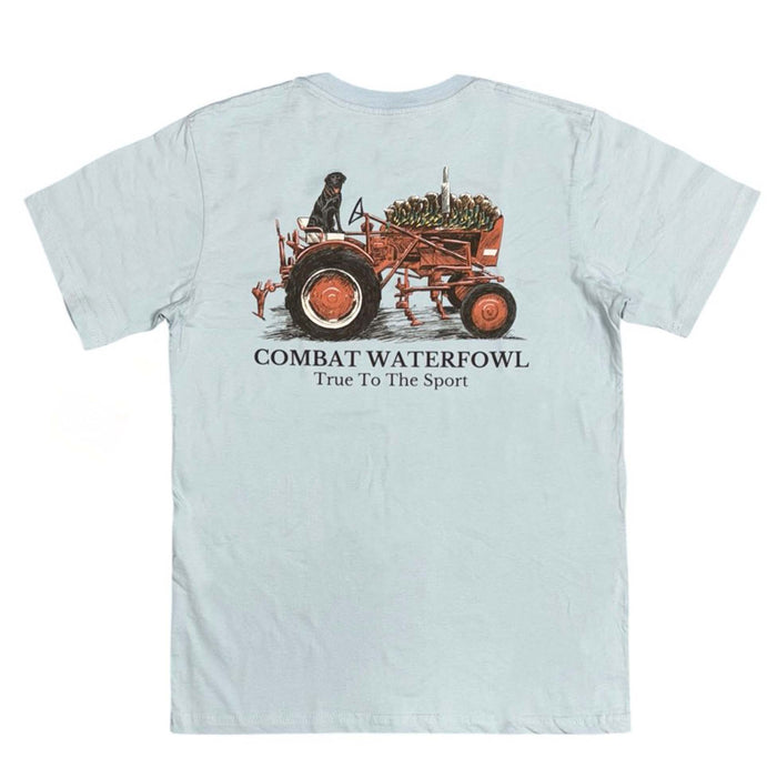 Light blue Combat Waterfowl t-shirt with a black lab riding a red tractor carrying duck decoys and “True to the Sport” text below.
