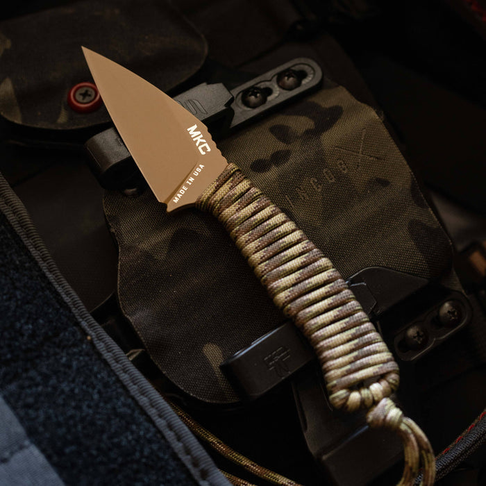 TRAIL GOAT knife with a coy/multicam finish, featuring a paracord handle, placed on a tactical background.