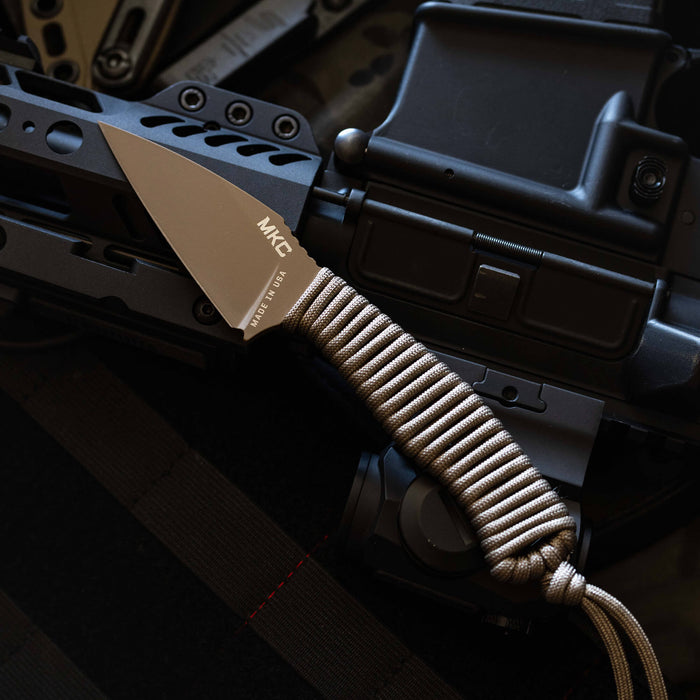 TRAIL GOAT knife with a coy olive drab handle, resting on tactical gear, showcasing its rugged design and functionality.