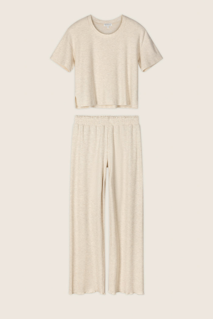 The P.J. Salvage Weekend Waffles Light Oatmeal Long PJ Set includes a short-sleeve, crew-neck crop top and high-waisted, wide-leg pants in soft waffle fabric—ideal for cozy nights—shown against a neutral background.