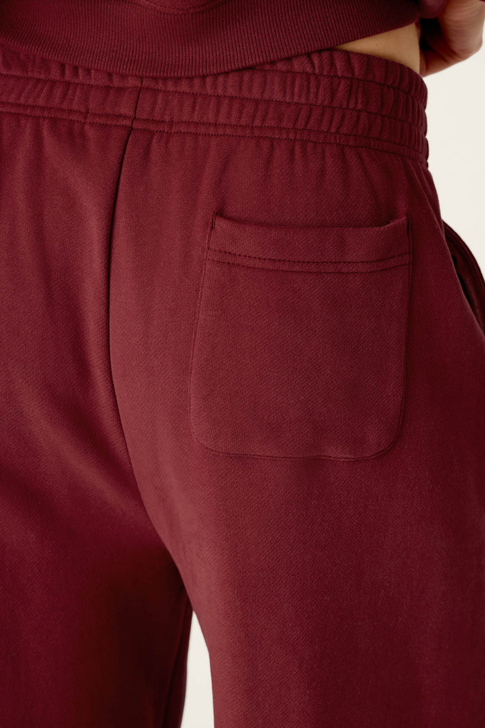 Close-up of a person wearing the P.J. Salvage Western Ways Dark Wine BFF Lounge Pants, highlighting the elastic waistband and a single back pocket on the right side. The fabric looks soft and comfortable.