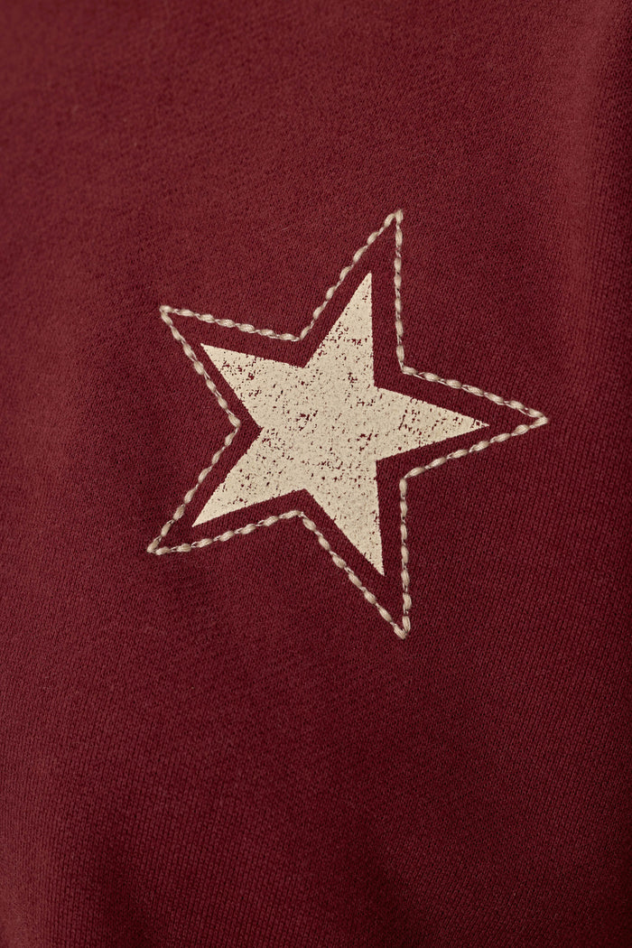 A white star with a stitched border is printed on the textured, dark wine fabric of the Western Ways BFF Lounge Pants by P.J. Salvage.