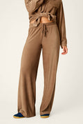 A person wearing the P.J. Salvage Western Ways Easy Itzy Corduroy Knit Lounge Pants in brown with a matching long-sleeve top, standing against a plain background. Only the lower face and body are visible.