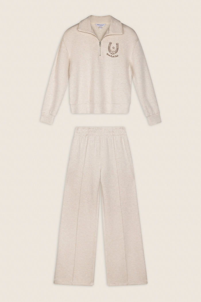 P.J. Salvage Western Ways Good Luck Club Over Night Pullover in beige, a long-sleeve zip-up top with a horseshoe emblem on the chest, paired with matching loose-fit elastic waistband pants, displayed flat against a neutral background.