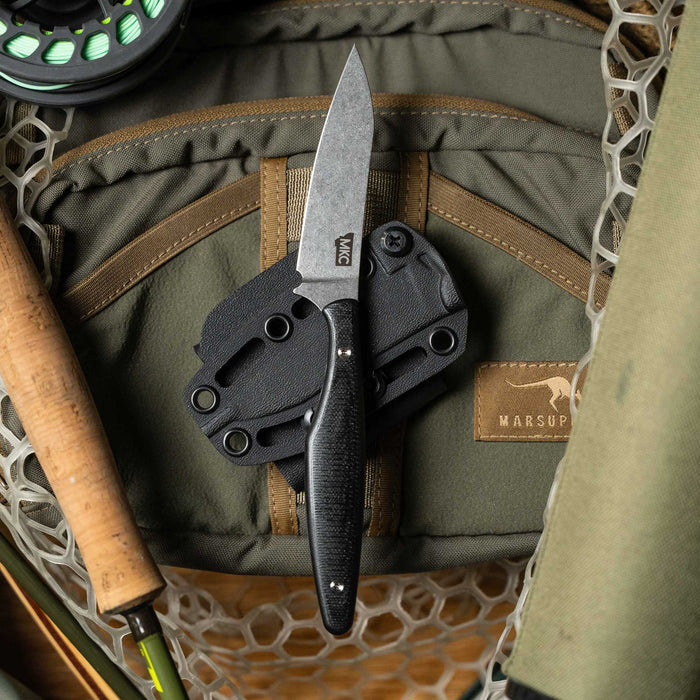 WESTSLOPE Black knife resting on a tactical pouch, surrounded by fishing gear and outdoor equipment.