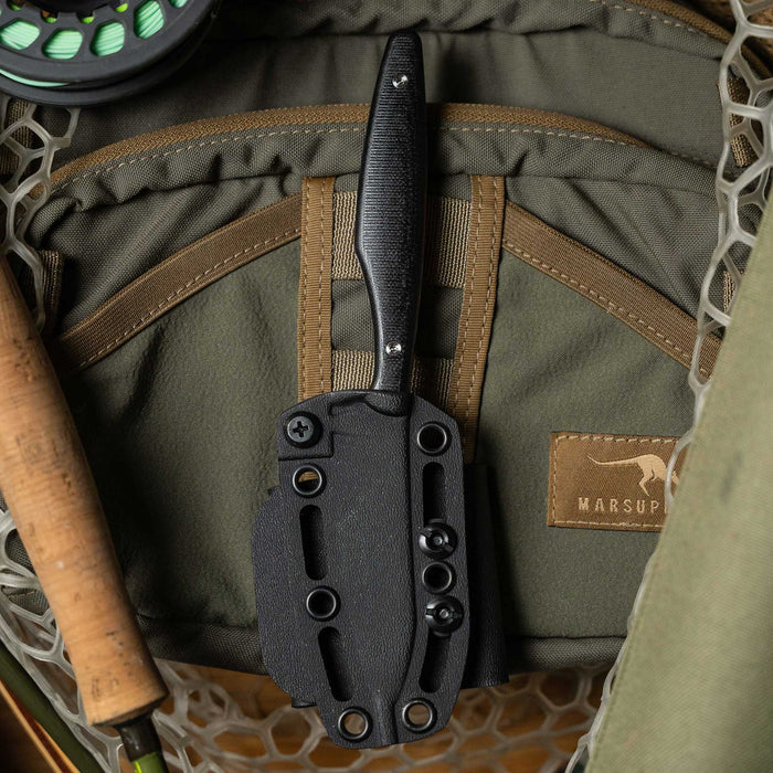 Black WESTSLOPE knife with a sheath resting on a green outdoor gear background, ideal for fishing and outdoor activities.