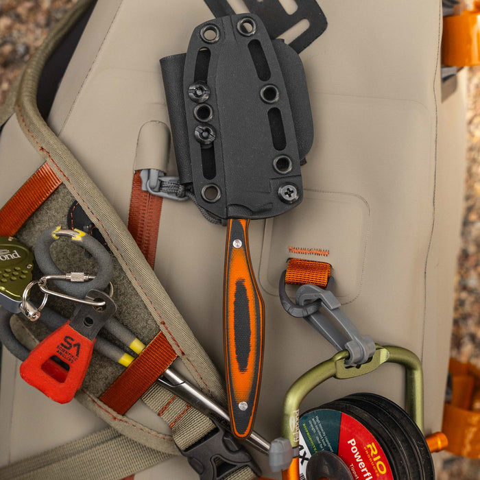 WESTSLOPE knife with an orange and black handle, secured in a sheath, resting on outdoor gear.