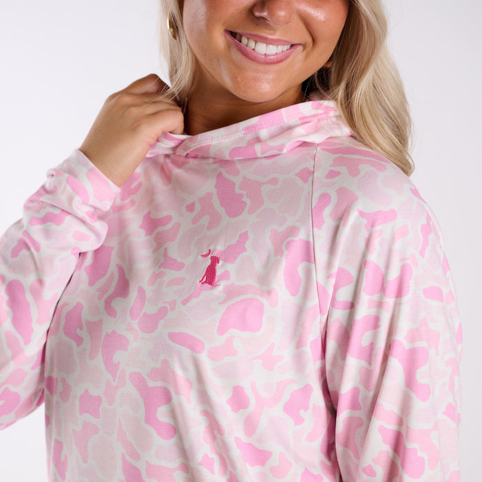 Person wearing a pink and white patterned hoodie with a logo on a white background
