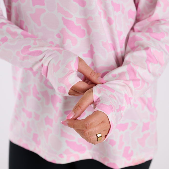 Close-up of a person wearing a pink and white patterned garment with a gold ring.